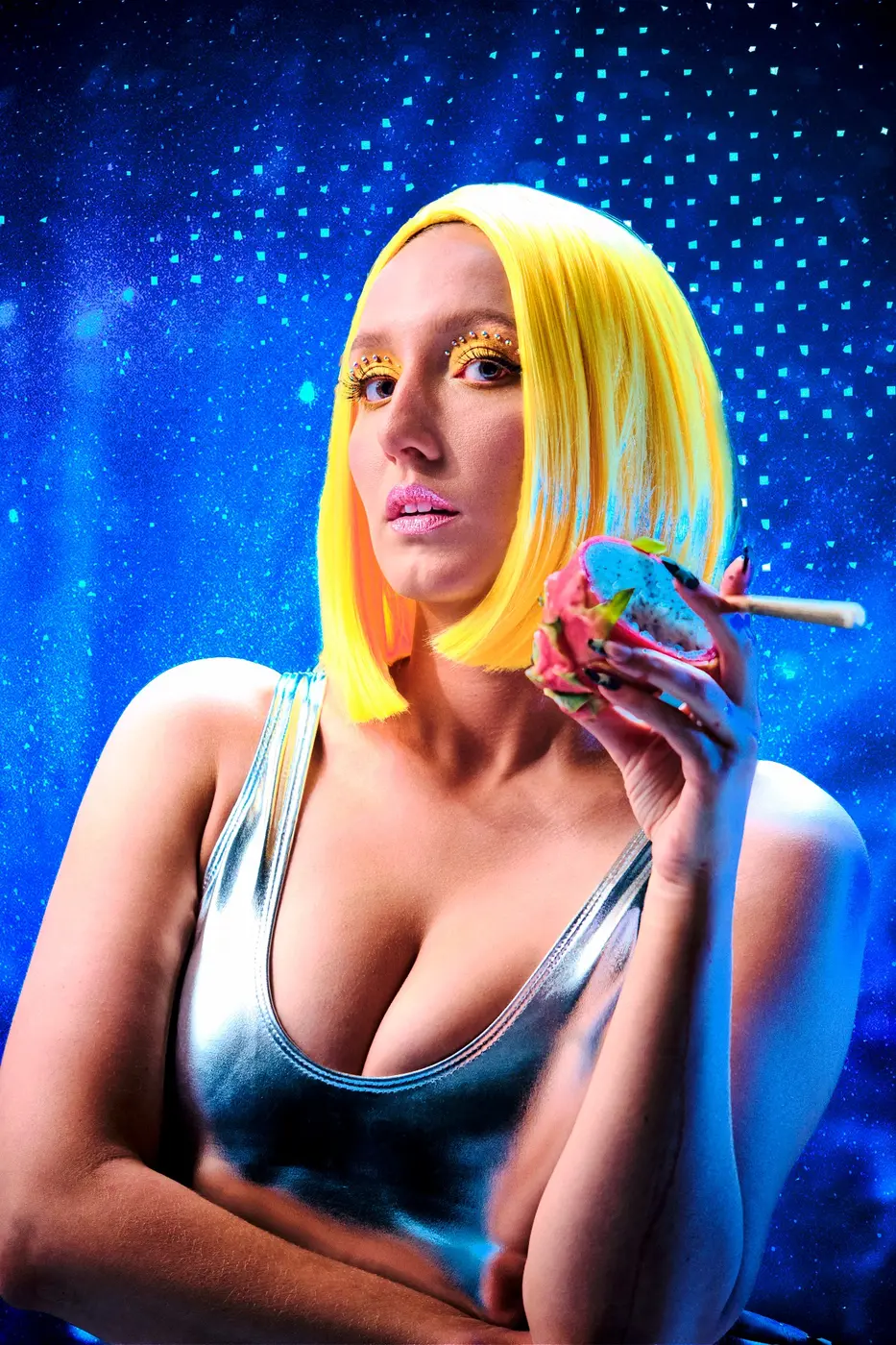 Model holding an infused pre-roll and dragonfruit