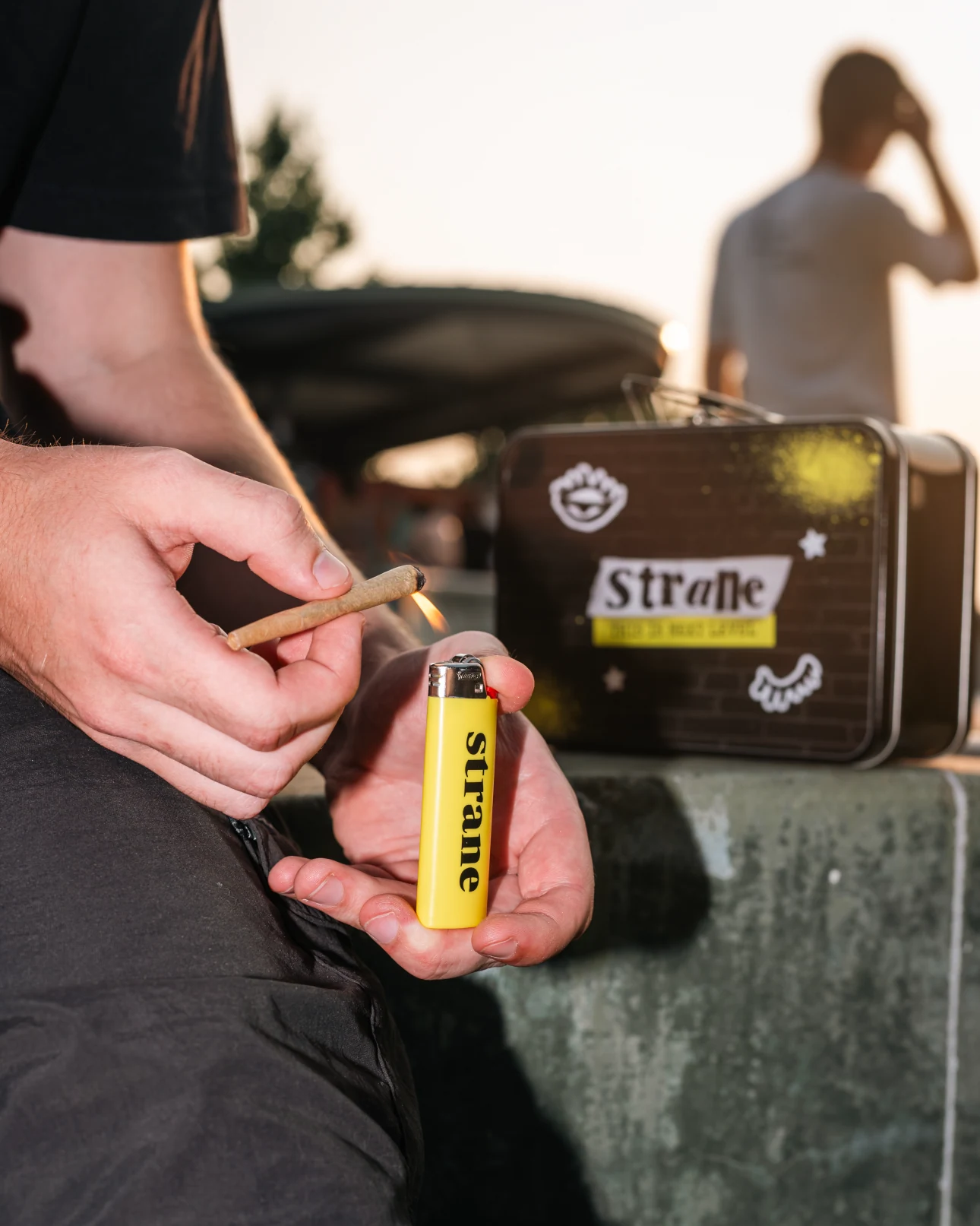 A close-up of Strane lighter and branded case at the skatepark